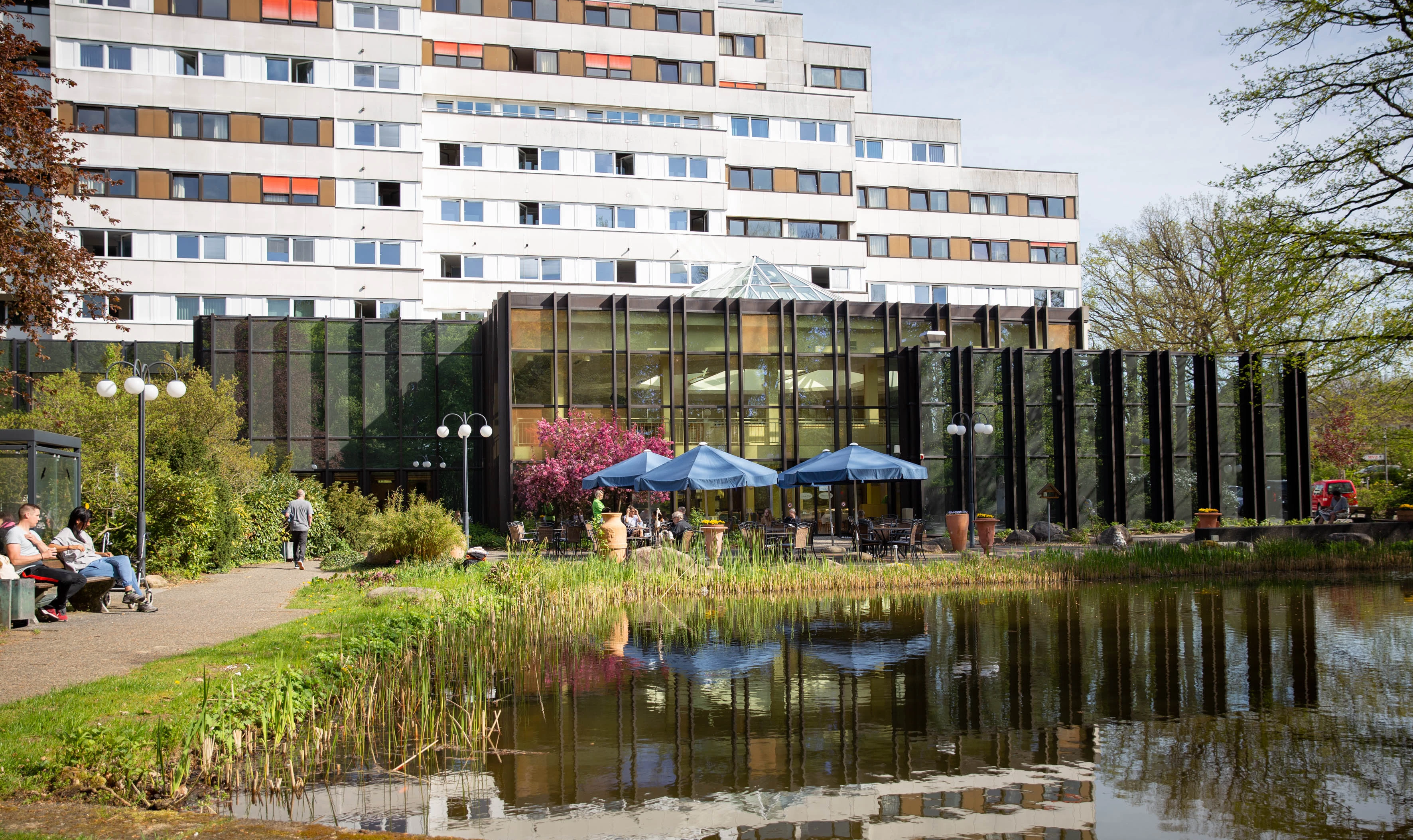 Die DianaKlinik. Im Vordergrund ein idyllischer Teich, der zur Erholung der Patienten beiträgt.