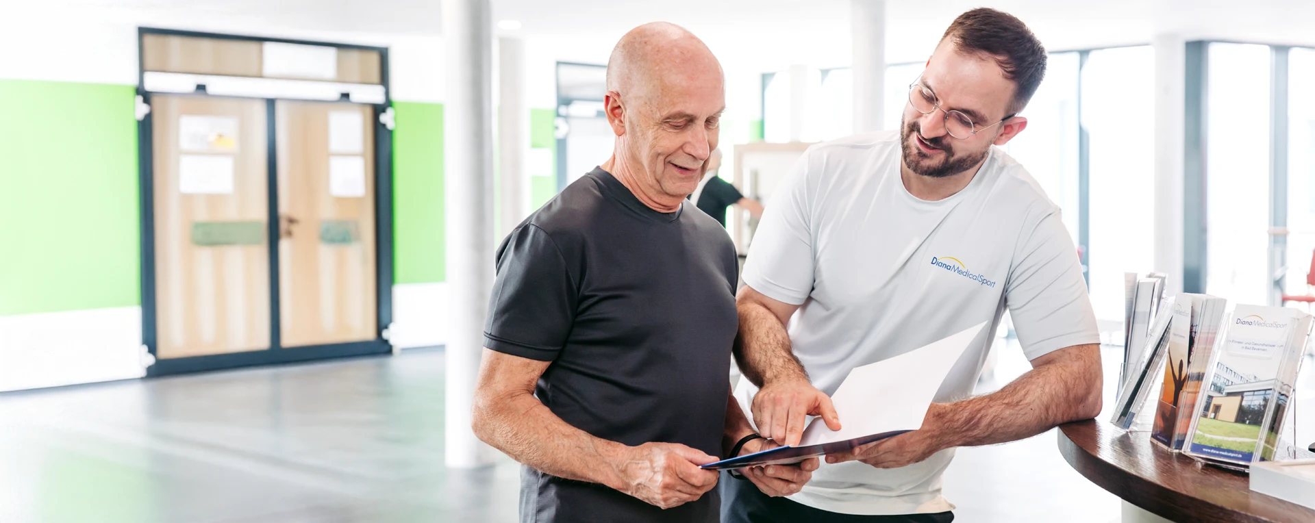 Ein Sporttherapeut von DianaMedicalSport erläutert einem neuen Mitglied das Konzept.